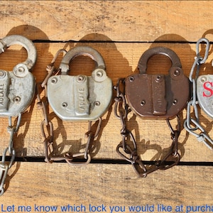 May include: Four vintage padlocks with chains, two silver padlocks with the word "ADLAKE" on them, one brown padlock, and one silver padlock marked "SOLD".