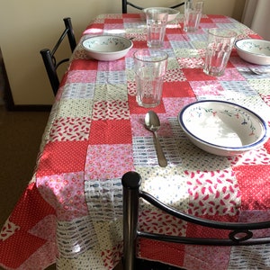 Könnte beinhalten: Eine rot-weiß karierte Tischdecke mit Patchwork-Design, das verschiedene Muster zeigt, darunter Fische, Wassermelonen und Blumenmuster. Auf dem Tisch stehen vier Gläser und zwei Schalen.