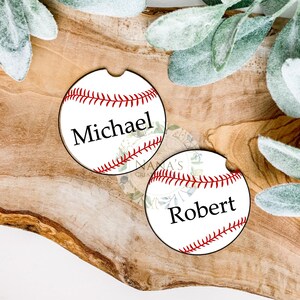 May include: Two white and red baseball-themed coasters with the names "Michael" and "Robert" printed on them.