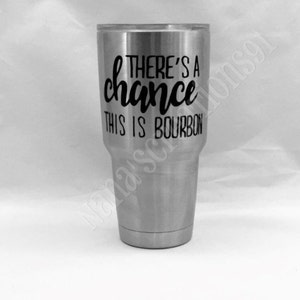 May include: A stainless steel tumbler with a black vinyl decal that reads "There's a chance this is bourbon".
