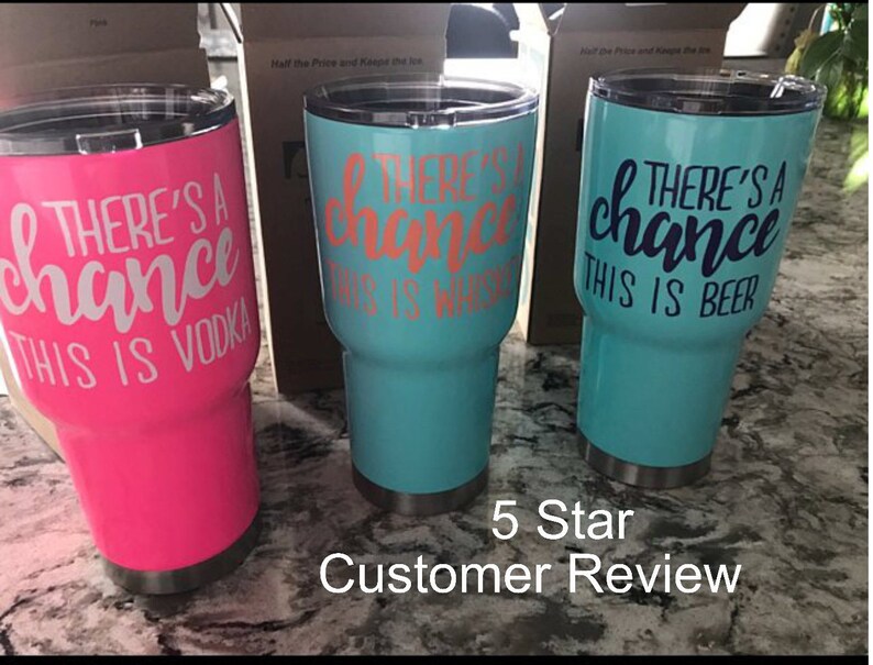 May include: Three stainless steel tumblers with a white design that reads "There's a chance this is ..."  The tumblers are pink, turquoise, and turquoise. The pink tumbler says "...vodka", the first turquoise tumbler says "...whiskey", and the second turquoise tumbler says "...beer".