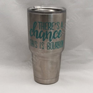 May include: A stainless steel tumbler with a teal green vinyl decal that reads "There's a chance this is bourbon".
