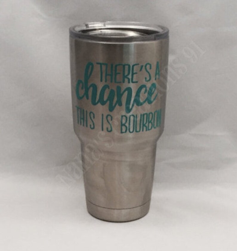 May include: A stainless steel tumbler with a teal green vinyl decal that reads "There's a chance this is bourbon".