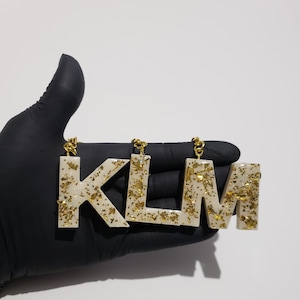 Charm para llavero dorado con escamas doradas y letras blancas