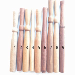 Peut inclure: Neuf aiguilles à tricoter en bois de différentes longueurs et couleurs. Les aiguilles sont numérotées de 1 à 9.