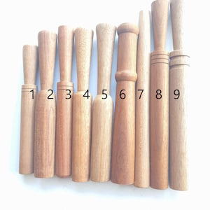 May include: Nine wooden mallets of varying lengths and diameters, numbered 1 through 9. The mallets are made of light brown wood and have a smooth, polished finish.