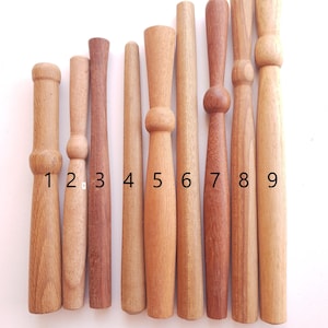 Peut inclure: Neuf chevilles en bois de différentes longueurs et diamètres, numérotées de 1 à 9. Les chevilles sont toutes de couleur bois naturel et ont une finition lisse.