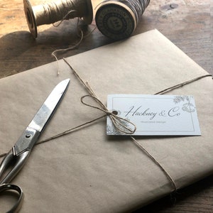 May include: A brown paper package tied with twine and a white gift tag that reads "Hackney & Co. Illustrated Design".