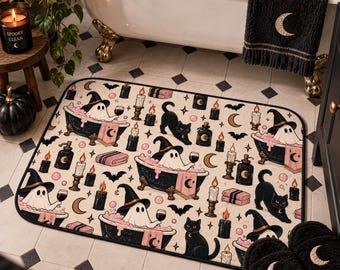 May include: A rectangular bath mat featuring a repeating pattern of ghosts wearing witch hats in claw-foot bathtubs with pink bubbles, black cats, lit candles, bats, crescent moons, and folded towels on a cream-colored background.