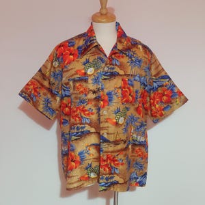 Op de afbeelding: Korte mouwen overhemd met een tropische print. Het overhemd heeft een bruine achtergrond met felrode en oranje bloemen, blauwe bladeren en ananassen. Het overhemd wordt getoond op een houten mannequin.