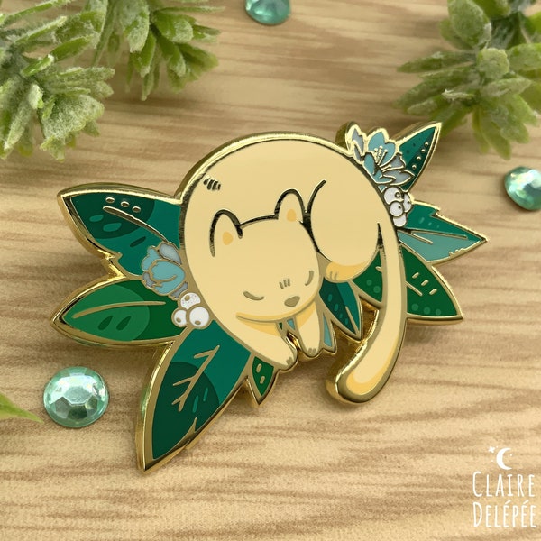 Pin doré de petit chat qui dort sur des plantes