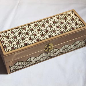 Coffret en bois gravé, décoré de motifs géométriques d'inspiration japonaise, avec compartiments intérieurs