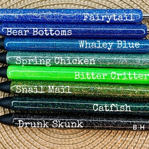 Puede incluir: Diez bol&iacute;grafos de purpurina con diferentes colores y nombres. Los nombres son: Fairytail, Bear Bottoms, Whaley Blue, Spring Chicken, Bitter Critter, Snail Mail, Drunk Skunk, Catfish y BH.