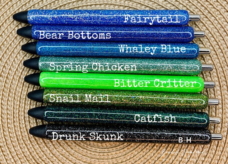 Puede incluir: Diez bol&iacute;grafos de purpurina con diferentes colores y nombres. Los nombres son: Fairytail, Bear Bottoms, Whaley Blue, Spring Chicken, Bitter Critter, Snail Mail, Drunk Skunk, Catfish y BH.