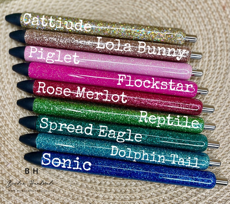 Puede incluir: Diez bol&iacute;grafos de purpurina con diferentes colores y nombres. Los nombres son: Cattitude, Lola Bunny, Piglet, Flockstar, Rose Merlot, Reptile, Spread Eagle, Dolphin Tail, Sonic y BH.