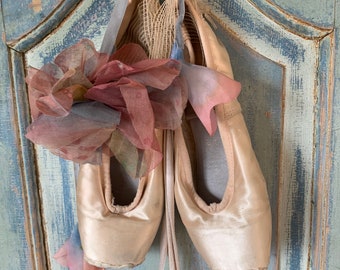 Three pair of old used dancingshoes with a beautiful antic corsage