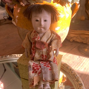 Antic little Chinese doll still in its original clothes