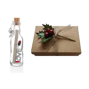 May include: A glass bottle with a cork stopper and a rolled up piece of paper inside. The bottle is decorated with a red rose and the word "LOVE" in silver letters. The bottle is in a brown box with a hessian ribbon and a sprig of holly with red berries.