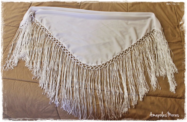 May include: White shawl with a crocheted border and long fringe. The shawl is made of a lightweight fabric and is perfect for adding a touch of elegance to any outfit.