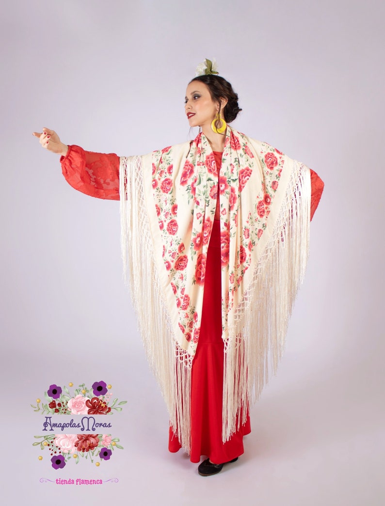 Op de afbeelding: Een vrouw in een rode jurk en een cr&egrave;mekleurige sjaal met rode rozenpatronen. De sjaal heeft lange franjes. De afbeelding bevat ook de tekst "Amapolas Moras" en "tienda flamenca".