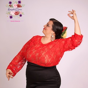 Pode incluir: Uma mulher vestindo um top de renda vermelho e uma saia preta. Ela está posando com o braço levantado e seu cabelo está penteado com uma flor. O texto "Amapollas Moras" e "tienda flamenca" é visível na imagem.
