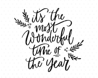 Könnte beinhalten: Schwarzer Kalligraphie-Text auf weißem Hintergrund mit der Aufschrift "It's the most Wonderful time of the year". Dekorative Zweige und Punkte akzentuieren den Text. Der Name des Künstlers, Angele Kamp, steht unten.