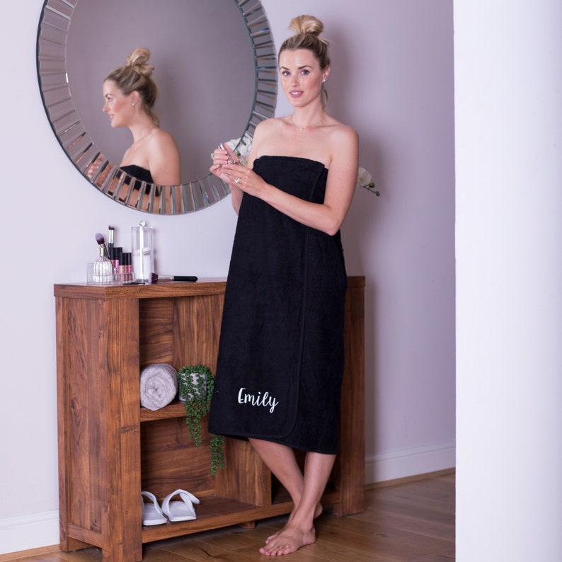 May include: A black bathrobe with the name "Emily" embroidered on the front. The robe is made of soft, absorbent material and is perfect for wrapping up after a shower or bath.