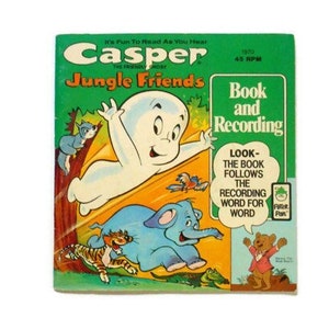 以下が含まれることがあります： カスペル・ザ・フレンドリー・ゴーストのヴィンテージレコードと本のセット。表紙には、カスペルがトラ、ゾウ、その他の動物と一緒にジャングルを飛んでいる様子が描かれています。タイトルは「カスペル・ジャングル・フレンズ」で、テキストには「It's Fun To Read As You Hear」と書いてあります。