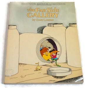 Op de afbeelding: Een vintage exemplaar van "The Far Side Gallery" van Gary Larson. De boekomslag toont een cartoonillustratie met een grillige scène van figuren in een cilindrische structuur. De titel is geel, met een lichtblauwe achtergrond.