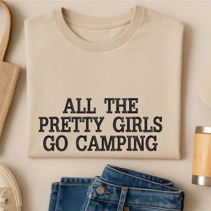 May include: A white ceramic mug with a black handle and the text "But First, Coffee" in a bold, black font. The mug is set against a blurred background, suggesting a cozy setting.