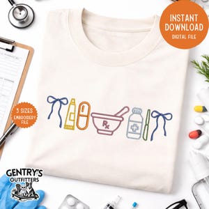 Op de afbeelding: Cr&egrave;mekleurig T-shirt met geborduurde apotheekthema-ontwerpen. Het ontwerp omvat een vijzel en stamper, een pil, een zalfbuis, een medicijnfles en een strik. De woorden "Direct downloaden Digitaal bestand" staan in een cirkel.