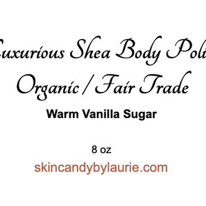 May include: A white label with a brown floral design and the text "Skin Candy by Lauric". The label also includes the text "Luxurious Shea Body Polish", "Organic/Fair Trade", "Warm Vanilla Sugar", and "8 oz". The website address "skincandybylaurie.com" is printed at the bottom of the label.