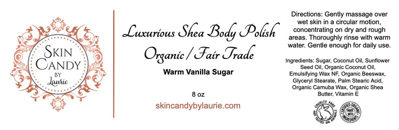 May include: A white label with a brown floral design and the text "Skin Candy by Lauric". The label also includes the text "Luxurious Shea Body Polish", "Organic/Fair Trade", "Warm Vanilla Sugar", and "8 oz". The website address "skincandybylaurie.com" is printed at the bottom of the label.