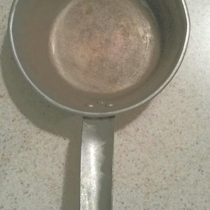 May include: A silver saucepan with a handle. The saucepan is empty and has a slightly worn surface.