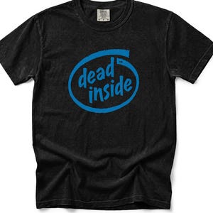 Könnte beinhalten: Ein schwarzes kurzärmeliges T-Shirt mit Rundhalsausschnitt und einer blauen Grafik auf der Brust. Die Grafik besteht aus einer blauen ovalen Umrandung mit dem Text "dead inside" in blauer Schreibschrift sowie einem kleinen Markenzeichen.