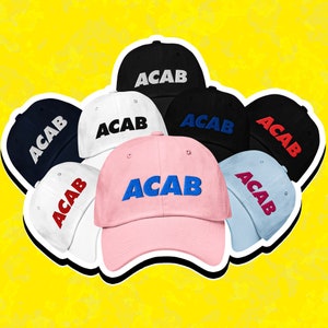Puede incluir: Una colección de siete gorras de béisbol de varios colores, cada una con el acrónimo "ACAB" bordado en la parte delantera en diferentes colores. Las gorras están dispuestas en círculo, con la gorra rosa en el centro.