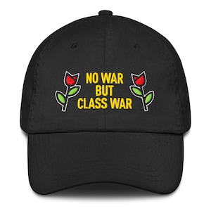May include: Black baseball cap featuring the embroidered phrase "NO WAR BUT CLASS WAR" in yellow. Two red roses with green leaves are on either side. A fashionable and practical headwear item.