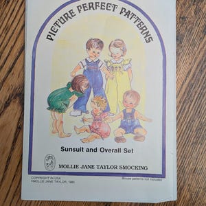 May include: A white paper sewing pattern envelope titled Picture Perfect Patterns Sunsuit and Overall Set by Mollie Jane Taylor Smocking. The cover features a color illustration of four children wearing various sunsuits and overalls, size 1-4.