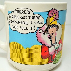 Vintage Carlton Karten Cartoon humorvolle Comic-Buch-Tasse "Es gibt irgendwo einen Verkauf, ich kann es nur fühlen!" Reiche Dame Frau Shopoholic!