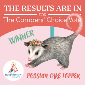 Op de afbeelding: Een illustratie van een opossum met een bloemenkrans, met het woord "Winner". De tekst luidt "The Results Are In For The Campers' Choice Vote" en "Possum Cake Topper". Het logo van camphollow.com is ook aanwezig.