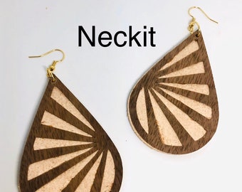 May include: A pair of brown teardrop-shaped earrings with a white sunburst design. The earrings have gold hooks.