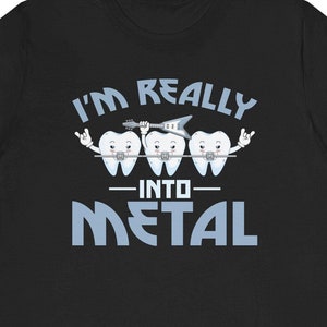May include: Black t-shirt with a white graphic of three teeth wearing braces and playing guitars. The text "I'm Really Into Metal" is written in blue.