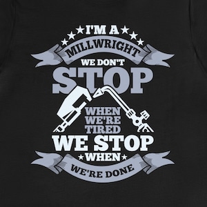 Op de afbeelding: Zwart T-shirt met een wit grafisch ontwerp met de tekst "Ik ben een monteur. We stoppen niet als we moe zijn. We stoppen als we klaar zijn."