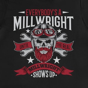 Op de afbeelding: Zwart T-shirt met een rood en wit grafisch ontwerp met een schedel met een bril en een baard. De tekst luidt "Everybody's a Millwright Until the Real Millwright Shows Up."