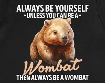 Op de afbeelding: Zwart T-shirt met een witte afbeelding van een wombat en de tekst "Always be yourself - unless you can be a - Wombat then always be a wombat."