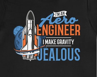 Op de afbeelding: Zwart T-shirt met een afbeelding van een raket en de tekst "I'm an Aero Engineer I make gravity jealous".
