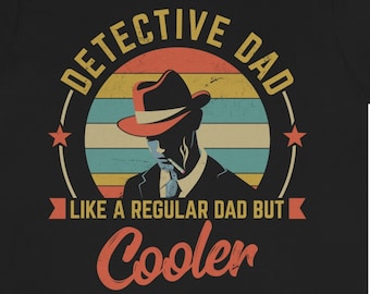 Op de afbeelding: Zwart T-shirt met een retro-grafische afbeelding van een man in een fedora, zonnebril en pak. De afbeelding zegt "Detective Dad - Like a regular dad but cooler".