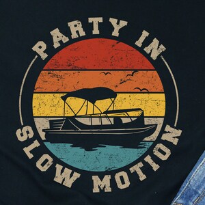 May include: Black t-shirt with a vintage-style graphic of a boat with the text "Party in Slow Motion".