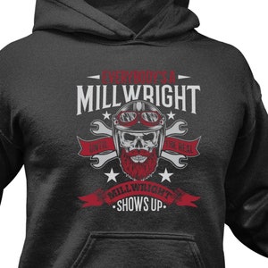 May include: A dark grey hooded sweatshirt with a graphic design featuring a skull with a beard and the text "A Millwright Don't Quit, A Millwright Shows Up".