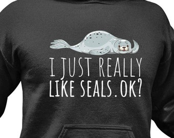 May include: A black hooded sweatshirt with a cartoon seal and the text "I just really like seals. Ok?"